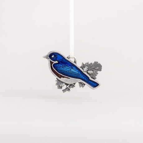 Decorative bluebird ornament with blue wings and silver body on a white background