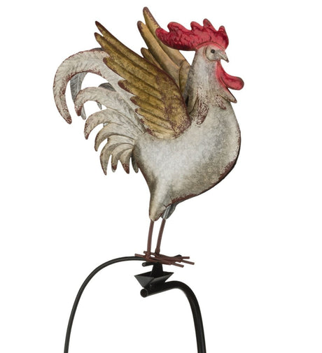 A metal garden stake featuring a colorful rooster with detailed feathers, perched on a rocker that moves in the wind.