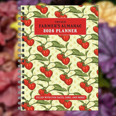 The Old Farmer's Almanac 2026 spiral bound planner notebook with repeated tomato on the vine illustration on a light yellow cover