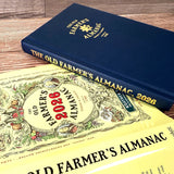 Two editions of The Old Farmer's Almanac on a wooden surface