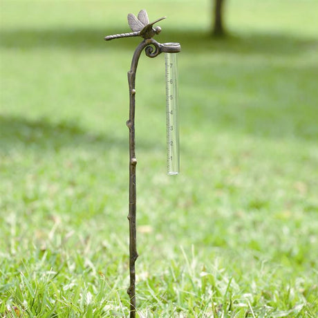 A delicate dragonfly elegantly rests on an aluminum stake, holding a glass rain gauge for a functional yet stylish addition to your garden