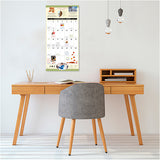 Wooden desk with gray chair and calendar on wall in room