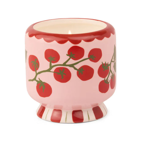 Ceramic candle vessel with red tomato design on a white background
