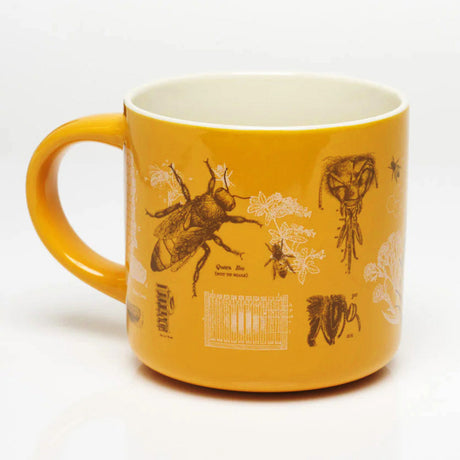 a yellow coffee mug with vintage illustrations honey bees