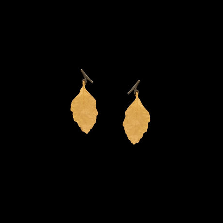 two bronze birch leaf earrings against a black background
