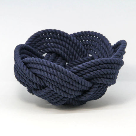 a hand woven cotton rope bowl in navy blue against a white background
