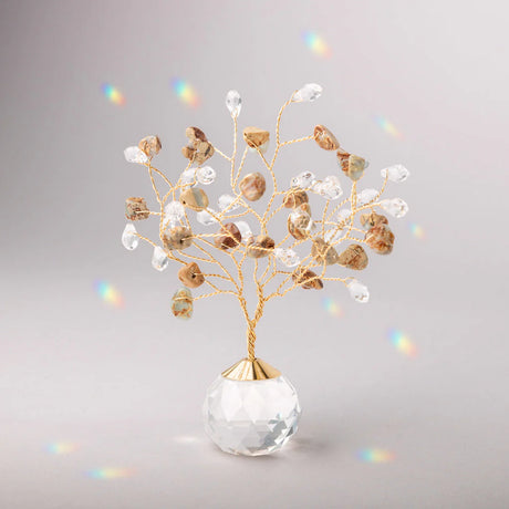 Decorative tree with gold branches and crystal base adorned with aqua terra stones and clear crystals casting tiny rainbows against the light gray background