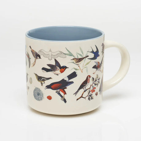 the other side of a white coffee mug with more vintage illustrations of birds wrapping around it, and a solid sky blue print on the inside of the mug