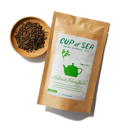 a kraft tea package with a white and green label that reads "Cup of Sea - Maine Seaweed Teas - Emerald Honeybush" with a graphic of a solid green tea kettle with seaweed shaped steam rising out of the spout next to a small round bowl filled with loose leaf tea
