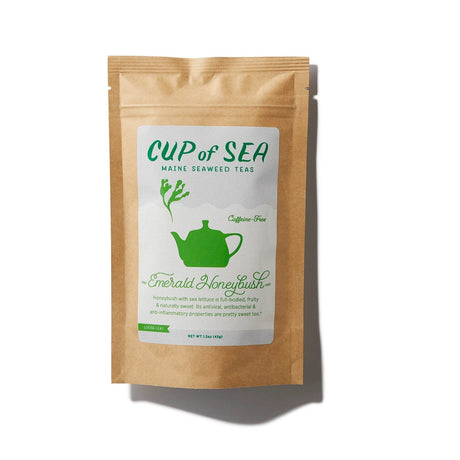 a kraft tea package with a white and green label that reads "Cup of Sea - Maine Seaweed Teas - Emerald Honeybush" with a graphic of a solid green tea kettle with seaweed shaped steam rising out of the spout