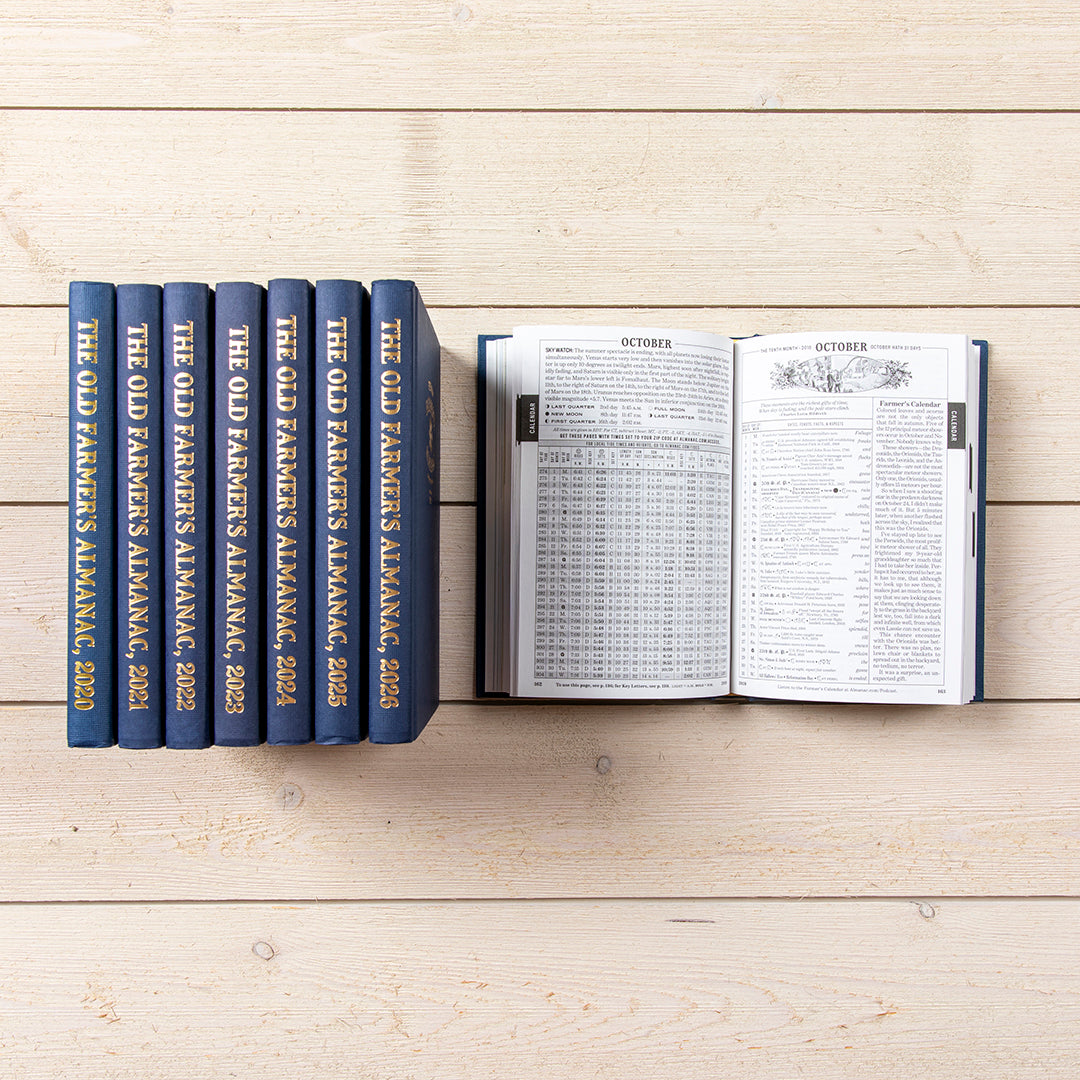 Set of 'The Old Farmer's Almanac' books on a wooden surface with one book open