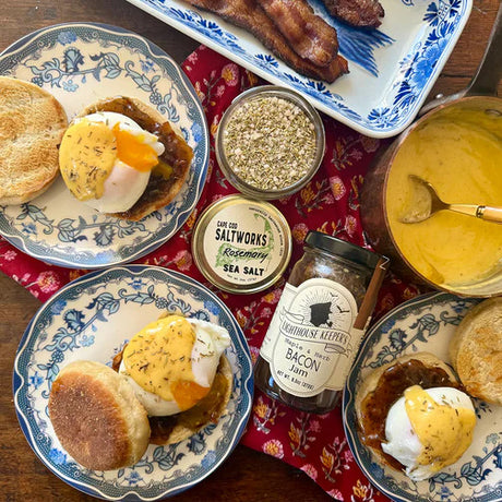 a table featuring a brunch spread of breakfast sandwiches on charming white and blue plates with a jar of maple herb bacon jam in the center