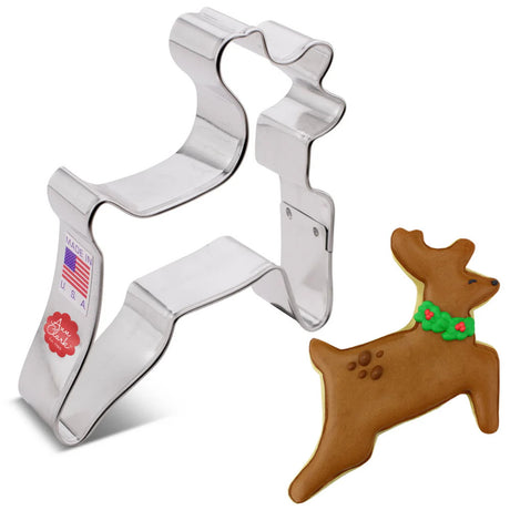 Leaping Reindeer Cookie Cutter displayed on a white background. The metal cutter is shaped like a reindeer in mid-leap, featuring clean lines and a joyful pose, ideal for creating festive holiday cookies. Next to the cutter is a fully decorated cookie with icing