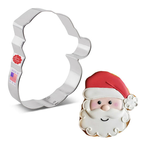 cookie cutter in the shape of Santa Claus' face next to a full color, fully decorated cookie of Santa's face with white bushy beard and red cap
