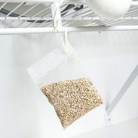 the scent away pouch hanging from a white wire kitchen shelf