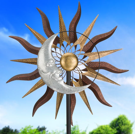 a wind spinner of undulating bronze sun rays with a silver crescent moon outlining the body of the sun, displayed in a garden against a blue sky