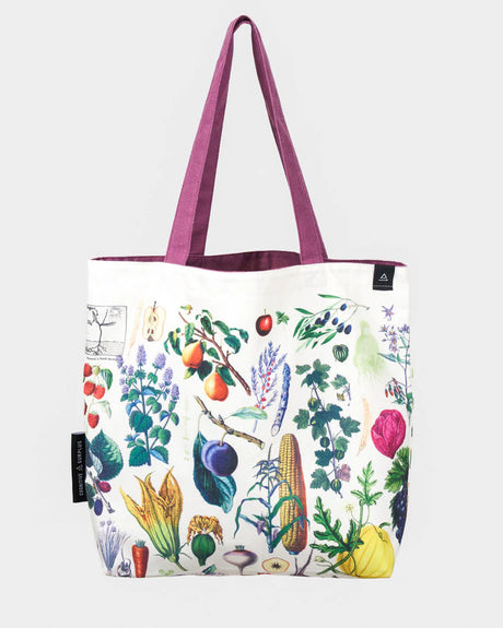 side one of the farmer's market tote; a white tote bag with lavender straps covered in vintage illustrations of fruits and veggies